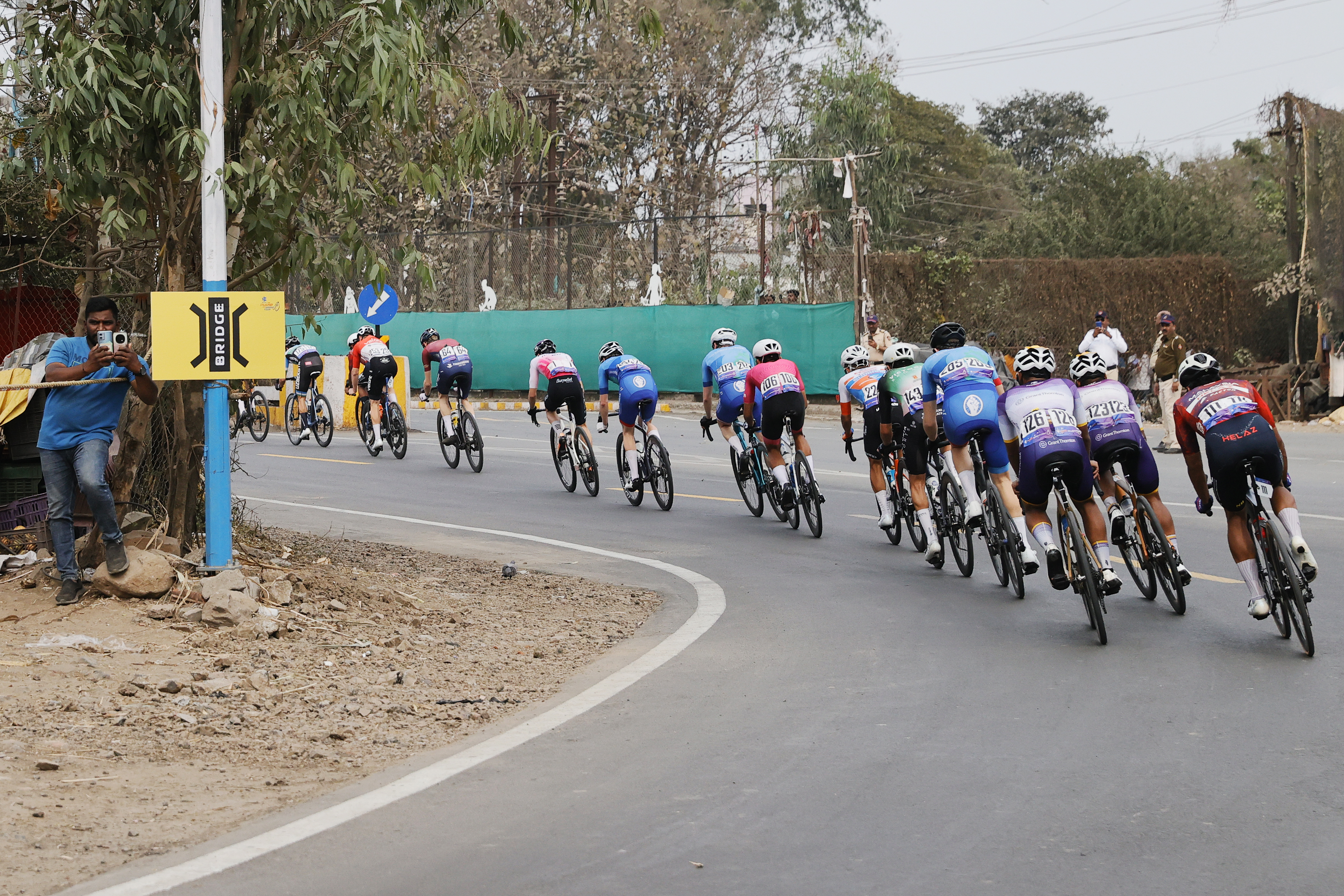 Riders zoom past the country side during stage two of the Bajaj Pune Grand Tour 2026 held in the City of Pune on the 21st January 2026.  The Pune Grand Tour marks India’s first entry into the global professional cycling calendar.   Owing to its UCI classification the PGT2026 will offer riders the opportunity to earn valuable ranking points that count toward qualification for the LA 2028 Summer Olympics.Photo by s Saikat Das /Sportzpics / PGT 2026