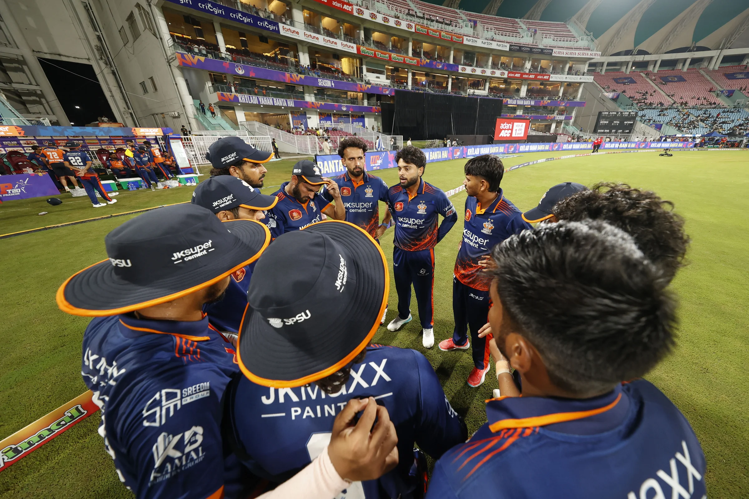Kashi Rudras huddle during the UPT20 League 2026 Season 4 opening clash between Kashi Rudras and defending champions Meerut Mavericks at Bharat Ratna Shri Atal Bihari Vajpayee Ekana Cricket Stadium, Lucknow, Uttar Pradesh, India, intense evening T20 action lights up Match 1 of the tournament.Photos by: Tamal Das / aceimages.in for UPT20